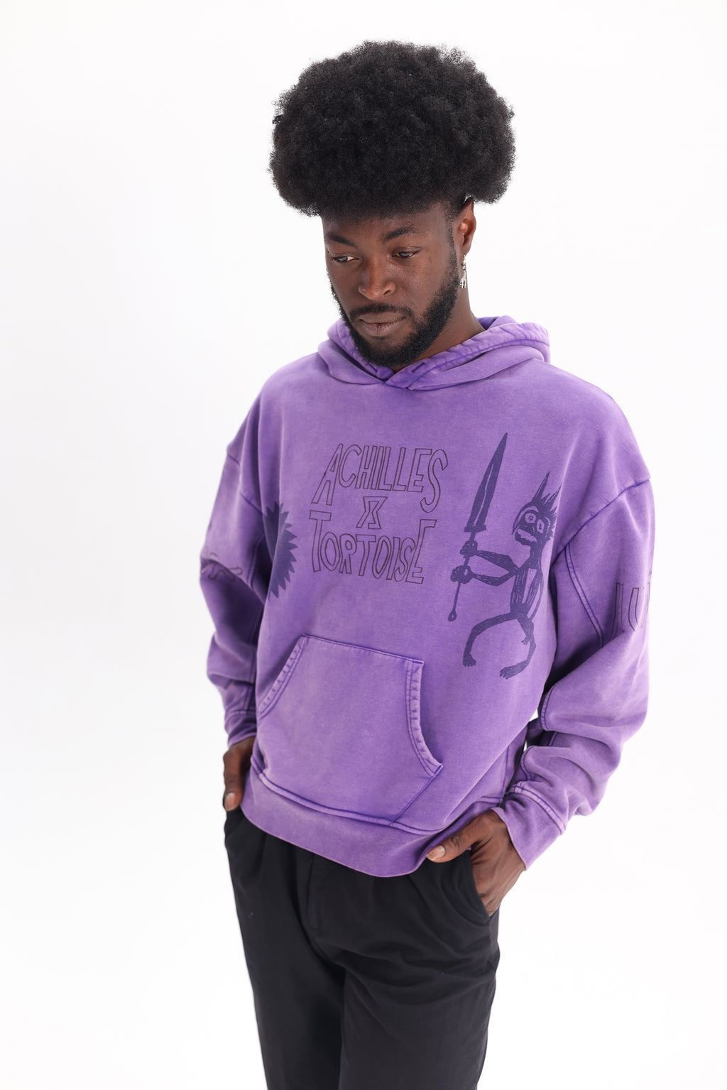 JP wearing Achilles and the Tortoise achilles purple hoodie with a graphic print on the front.