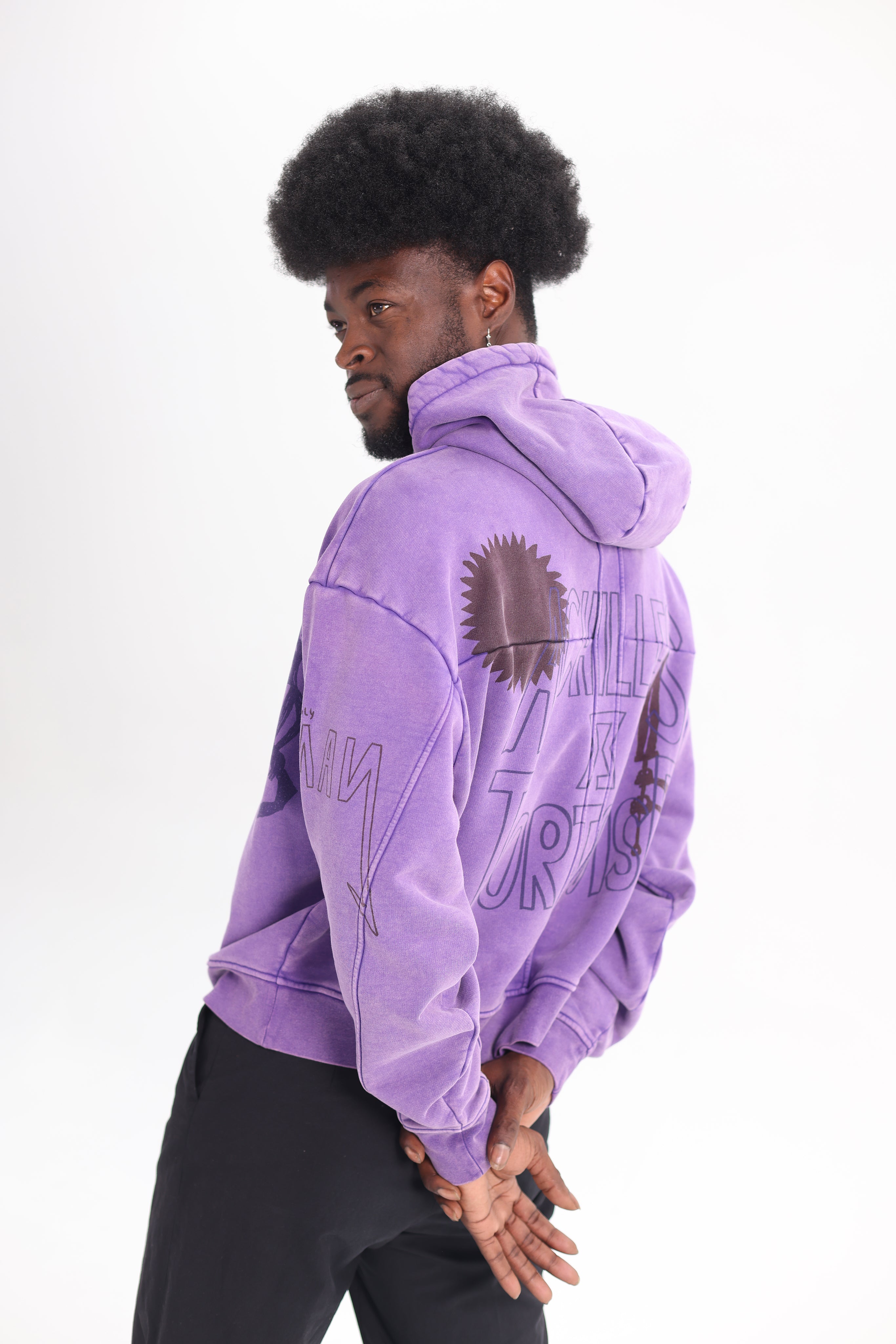 back view of JP wearing Achilles and the Tortoise achilles purple hoodie with a graphic print on the front. Amsterdam sustainable streetwear.