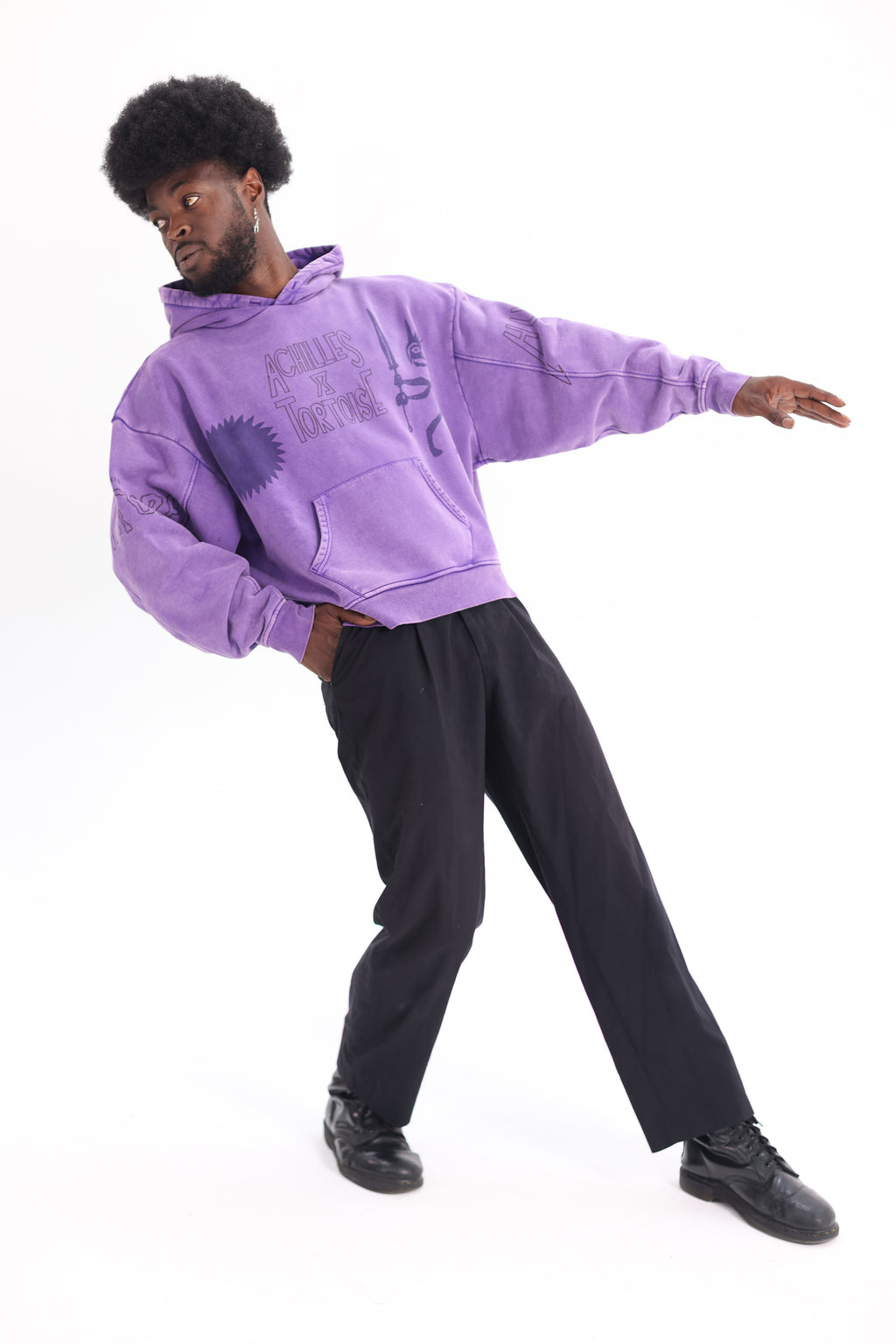 tilted front view of JP wearing Achilles and the Tortoise achilles purple hoodie with a graphic print on the front. Amsterdam sustainable streetwear.